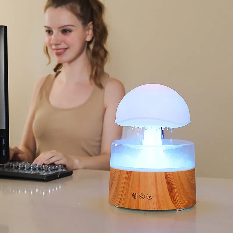 White cloud-shaped ultrasonic aroma diffuser and humidifier with simulated raindrops and coloured lights.