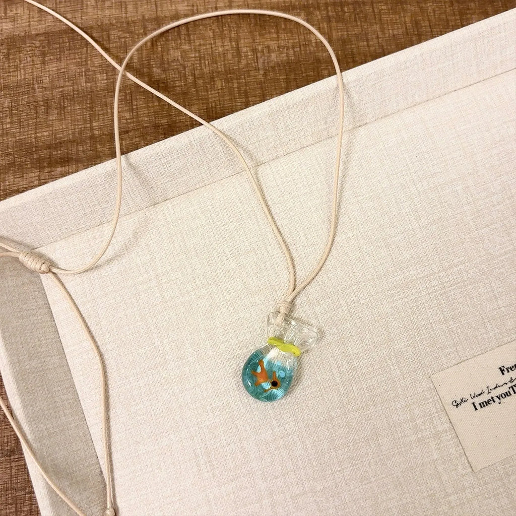 Women's necklace with coloured glaze skirt joker pendant on a beige cotton and linen chain, 45cm long.