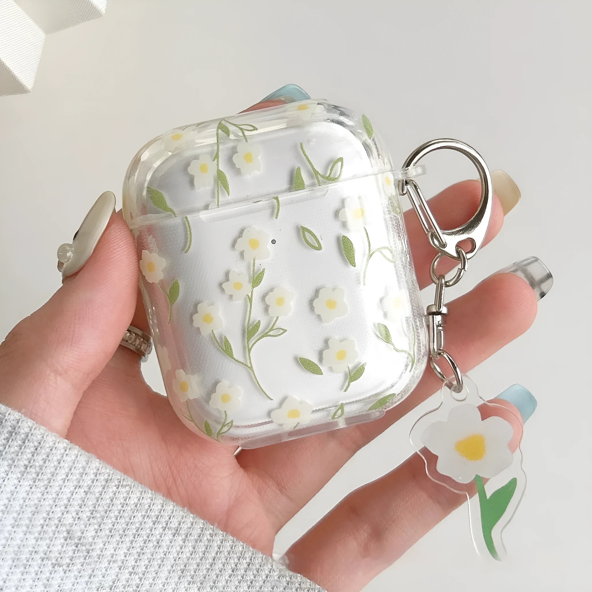 White floral pattern clear TPU protective case for Apple AirPods on a charging case.