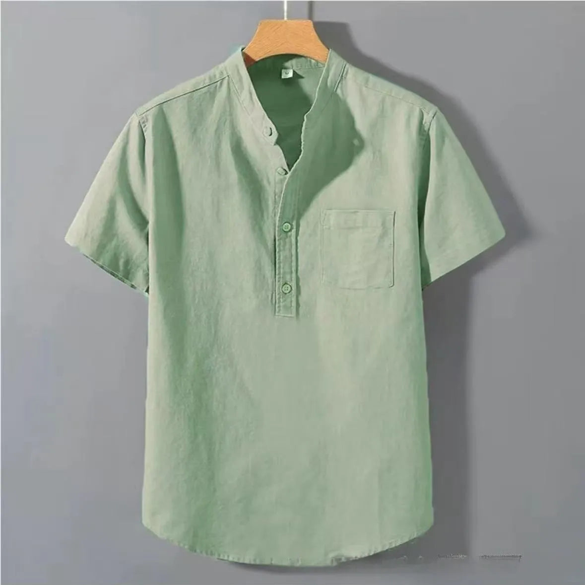 Man wearing a beige slub linen casual shirt with a stand collar and short sleeves.