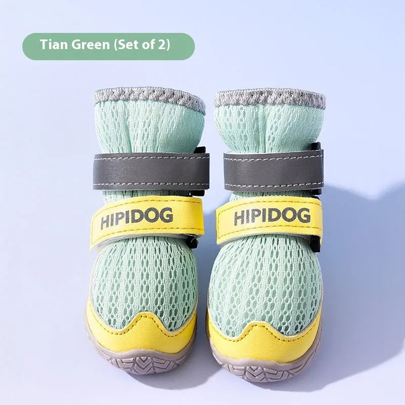 Pair of blue cartoon-style dog shoes with breathable PU uppers and anti-scald soles on a wooden surface.