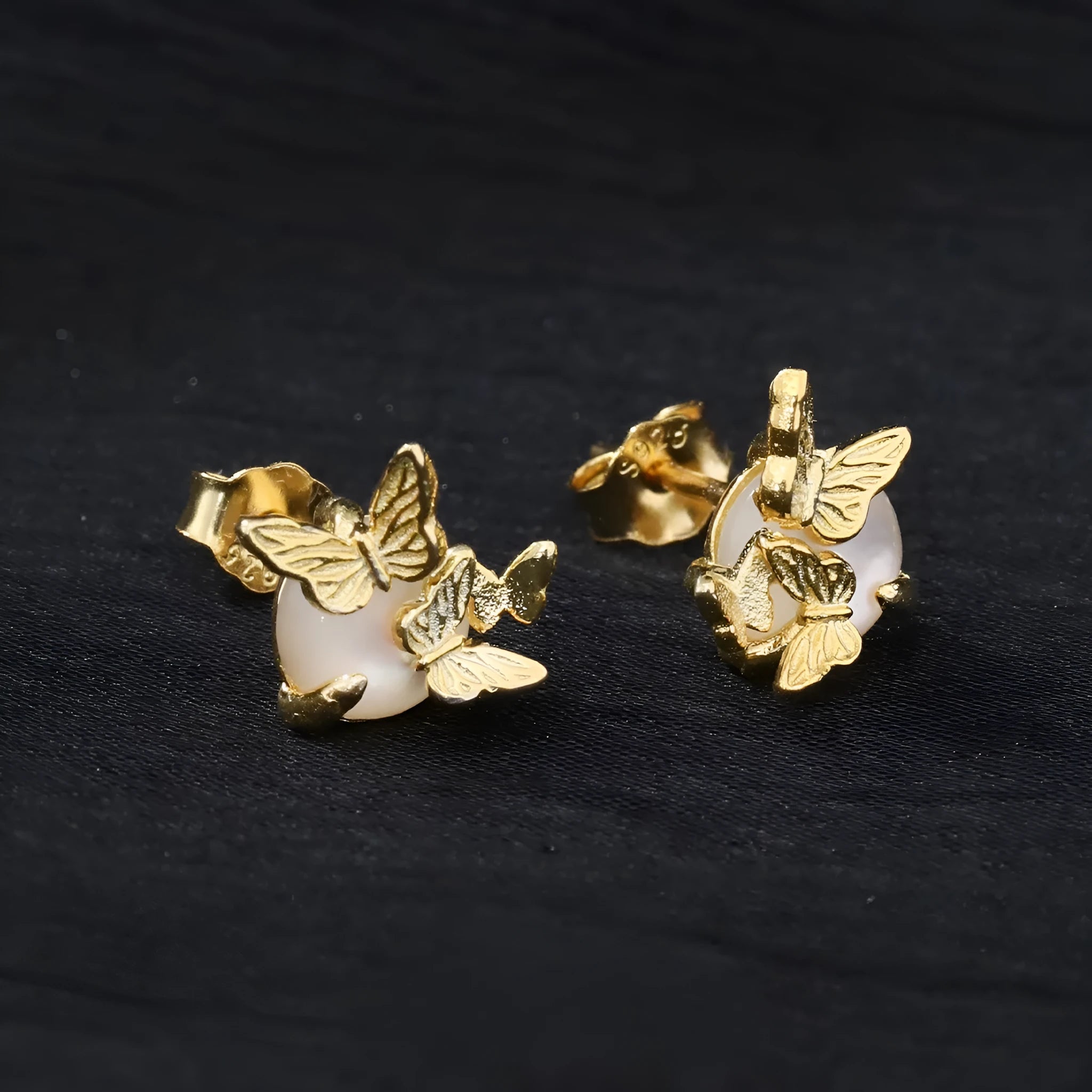 A pair of butterfly-shaped stud earrings in sterling silver with gold colour finish.