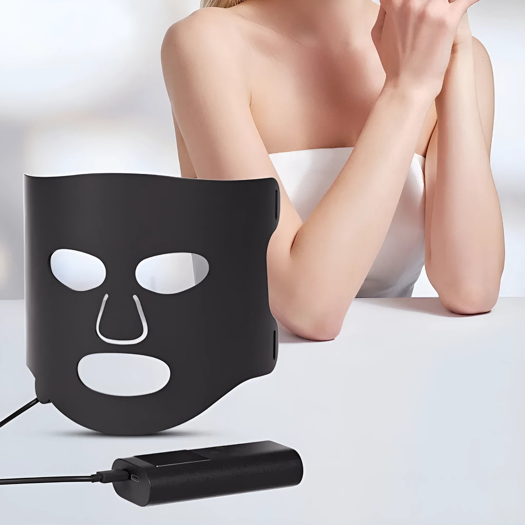 Black and white LED light therapy face mask with controller for home skin treatment.