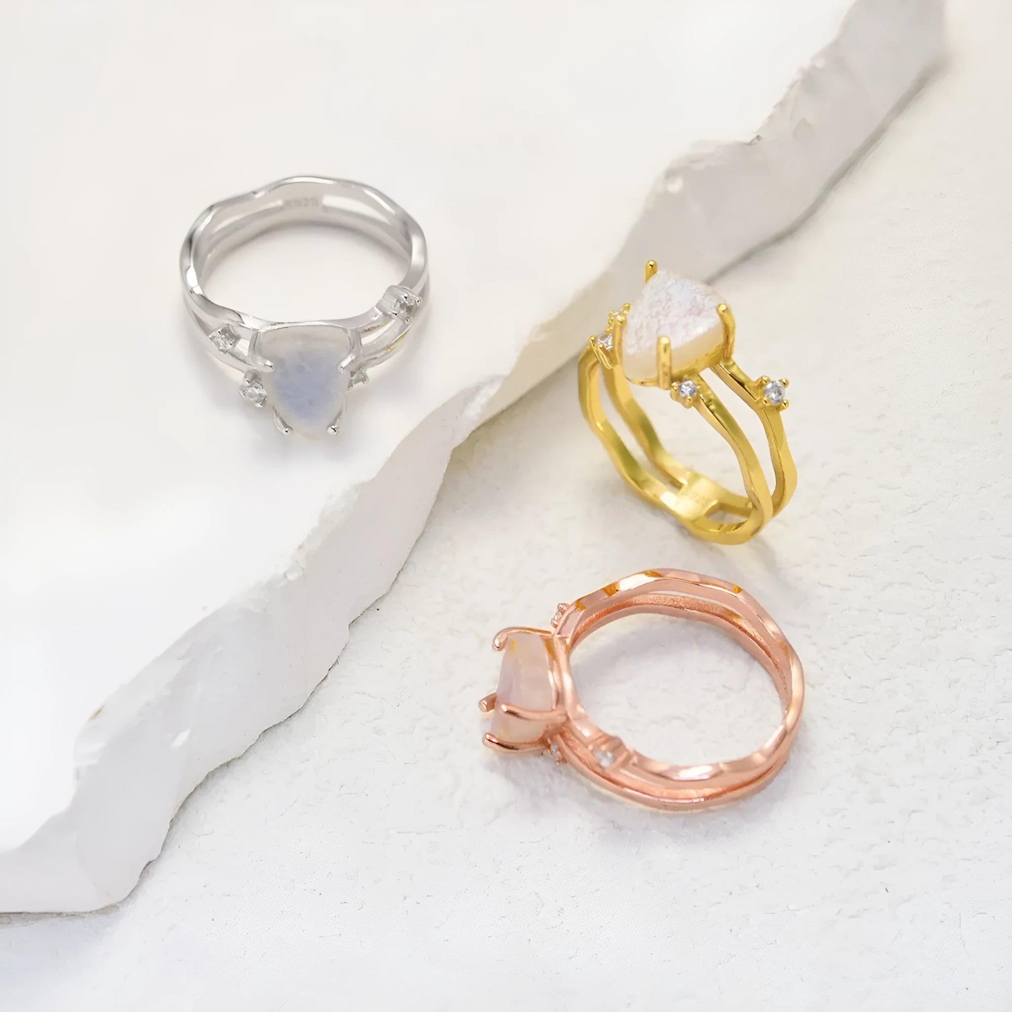 S925 silver ring with an irregular triangle-shaped moonstone in a geometric setting, shown in rose gold, white gold, and yellow gold finishes.