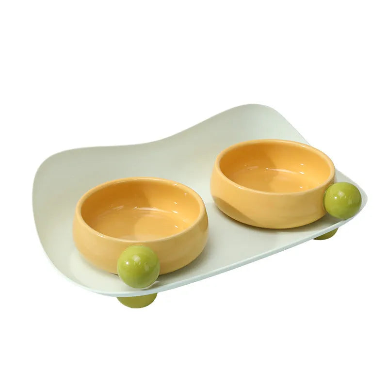 Ceramic raised double bowl set for pet food and water with a non-slip base in yellow.