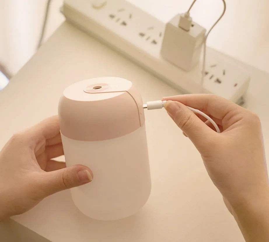 Small white cylindrical USB-powered humidifier with charging cable.