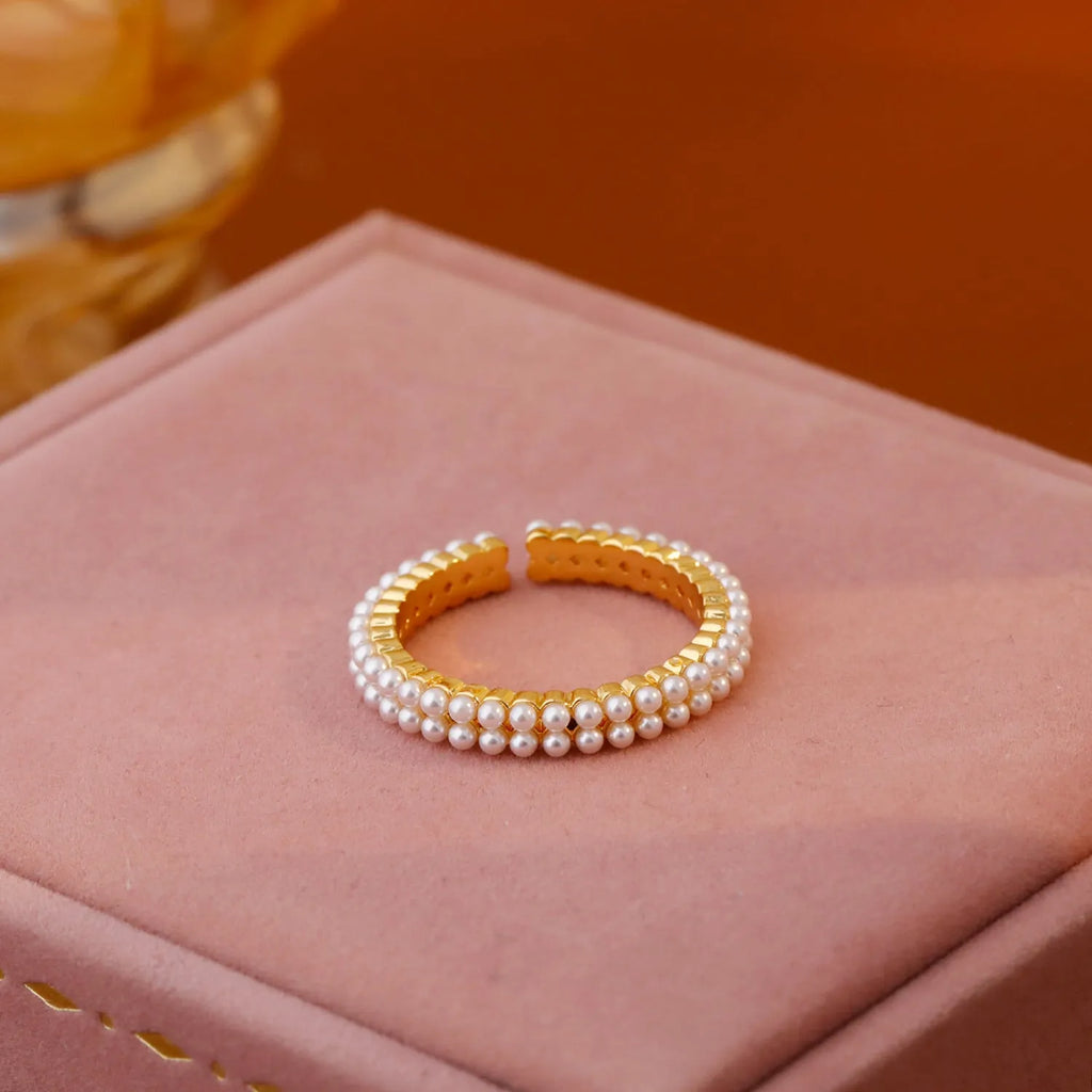Gold electroplated pearl ring with open mouth geometric design on female hand