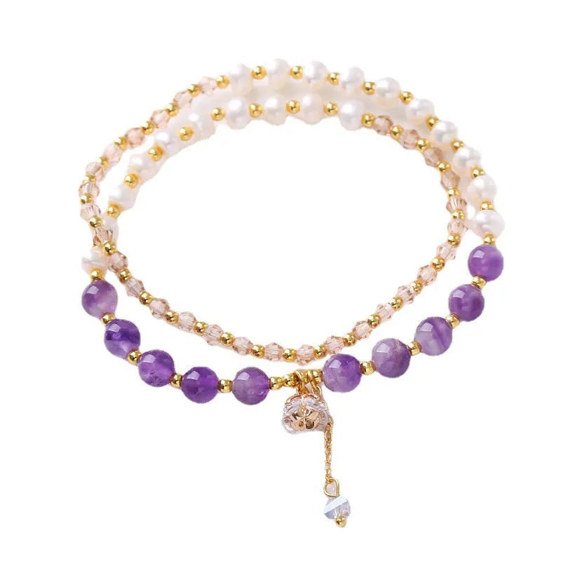 Close-up of a freshwater pearl and crystal double ring bracelet with a sliding bead closure.