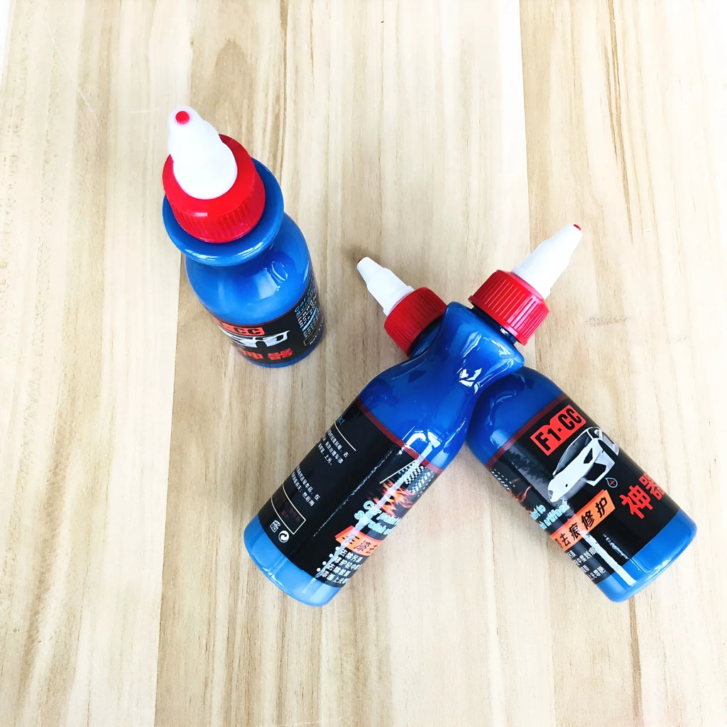 Small blue bottle of car scratch repair agent for wipe-on application to vehicle paint surfaces