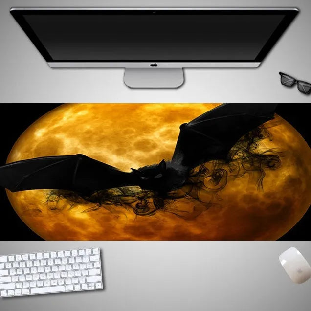 Large Halloween patterned gaming mouse pad on a desk showing non-slip rubber base and extra-long design.