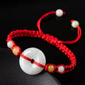 Burmese jade round pendant on an adjustable red rope bracelet with certificate.