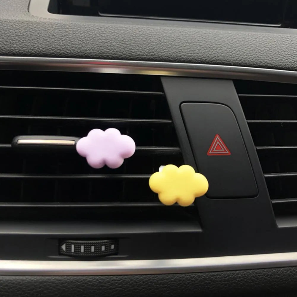 Resin cartoon car fragrance clip in pastel colours on a car air vent.