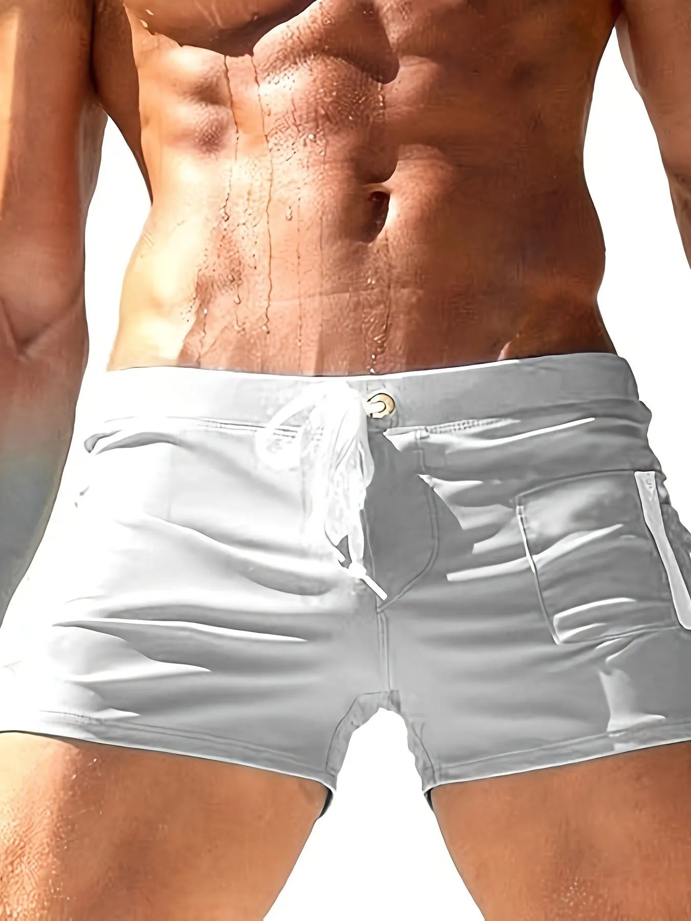 Men's solid colour polyester swimming trunks with high waist and lace-up brief design.