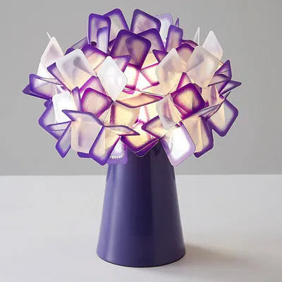 Nordic style decorative table lamp in a choice of colours including black, blue, and orange on a wooden surface.