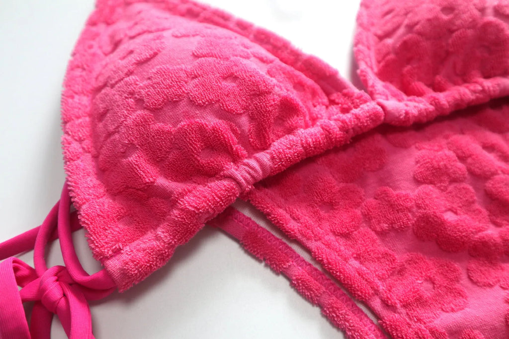 Women's bikini swimsuit with a lace-up back in flower fabric, shown in rose red and blue.