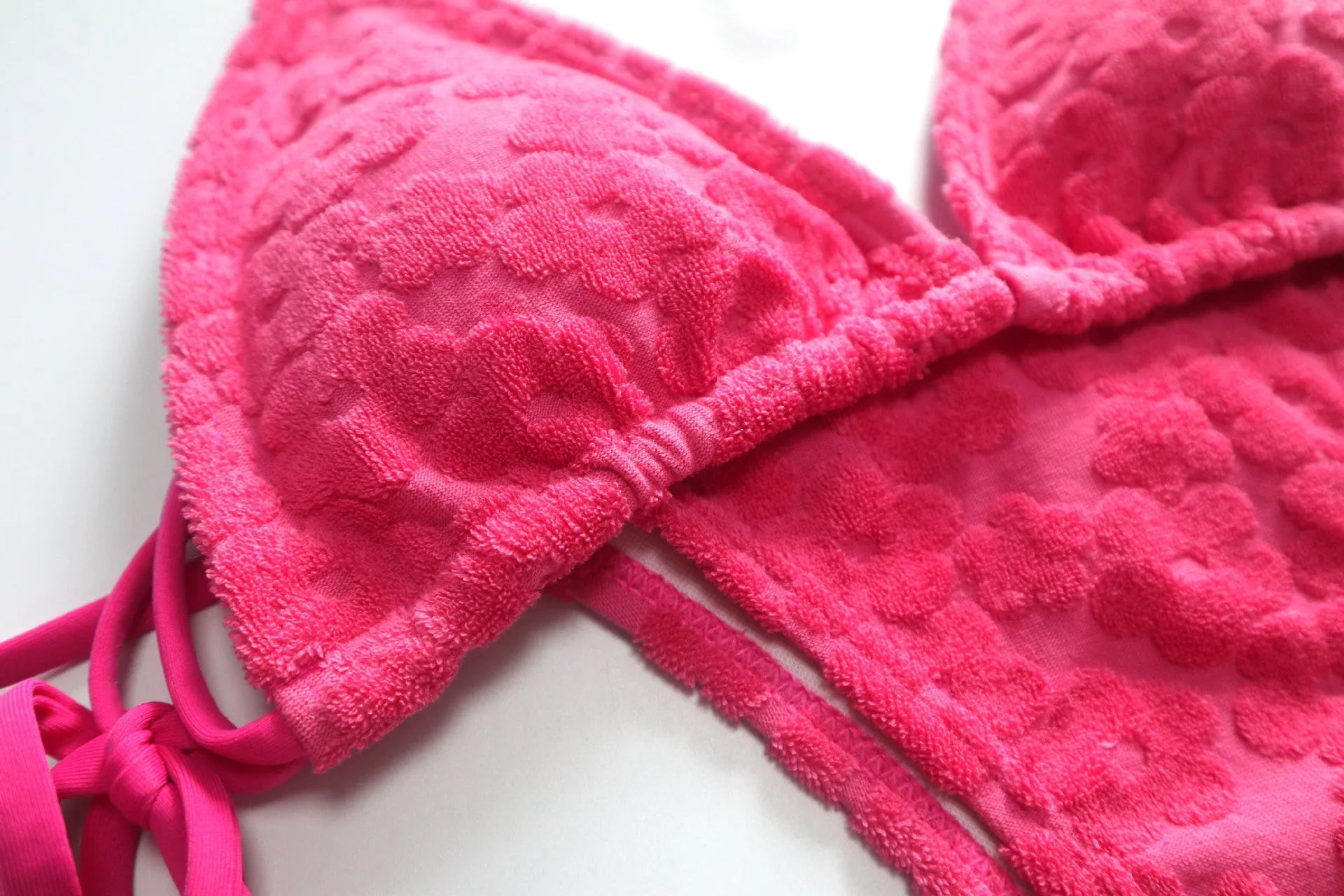 Women's bikini swimsuit with a lace-up back in flower fabric, shown in rose red and blue.