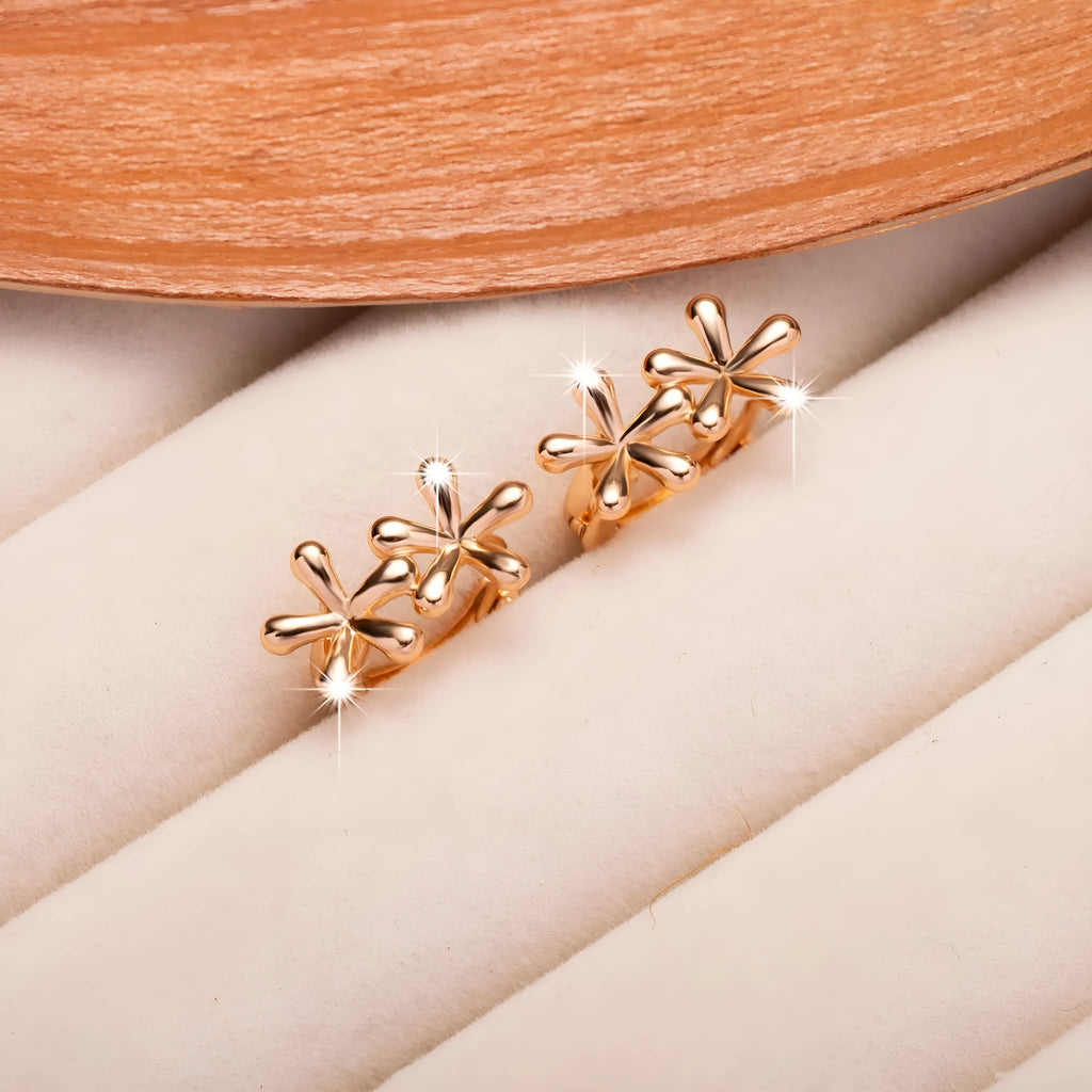 Circular rose gold earrings with a waterdrop flower pattern, shown front-on.
