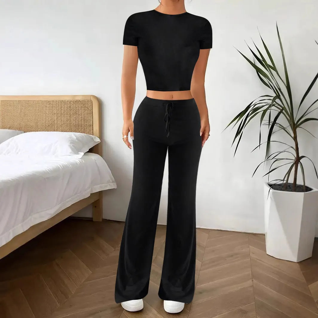 Black high-waist polyester trousers and matching short-sleeve t-shirt laid flat as a two-piece suit set.