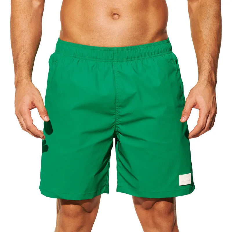 Men's solid colour quick-drying nylon sports shorts on a man, showing straight leg opening.