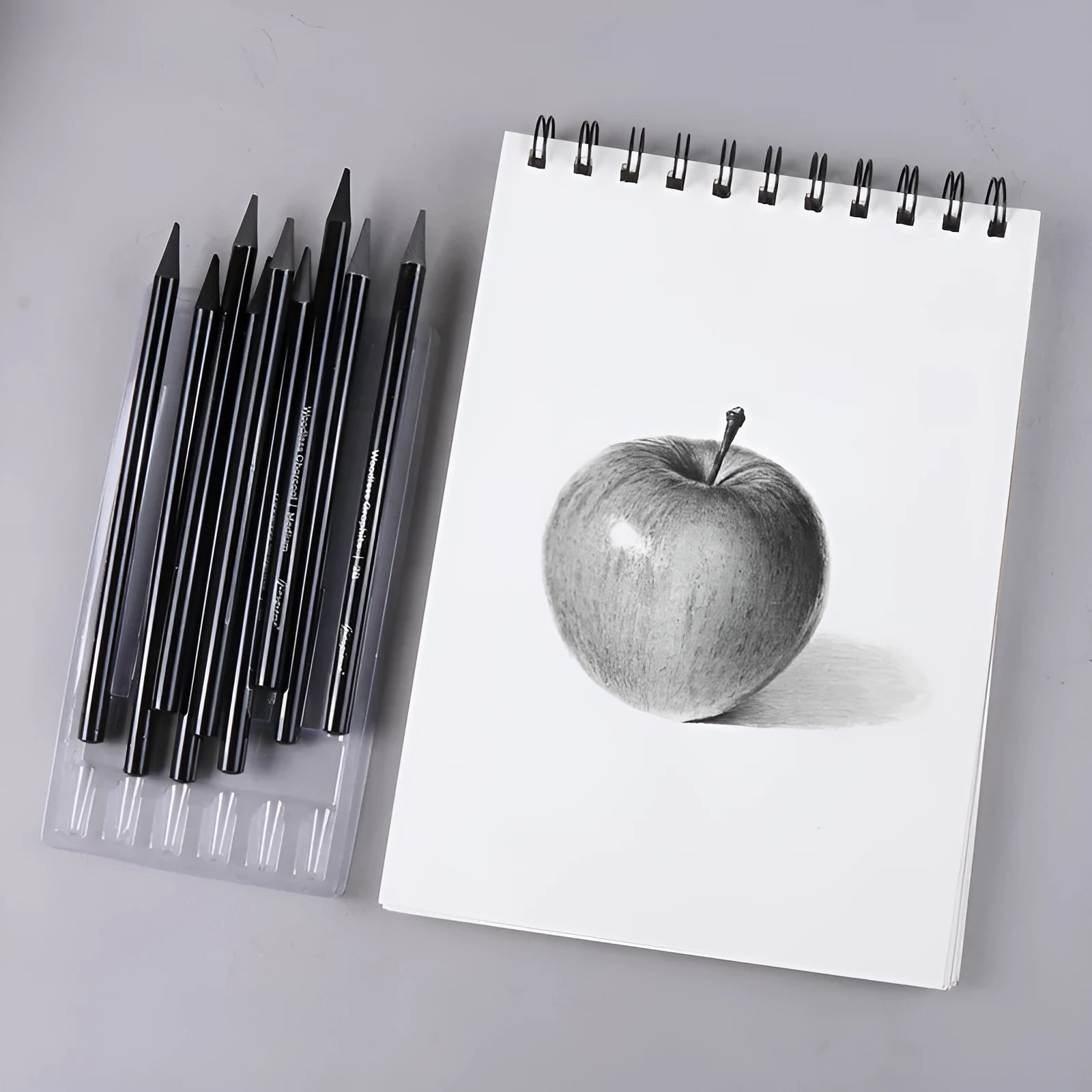 Set of six graphite and three carbonised art pencils in suction card packaging.