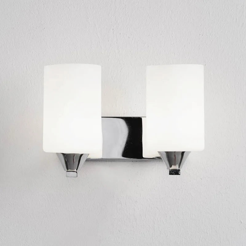 A modern chrome wall lamp with a clear glass shade, shown in single-head and double-head styles.