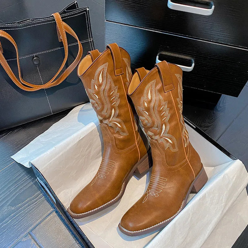 Brown women's mid-calf boots with embroidered pattern, round toe, and low square heel on a rubber sole.