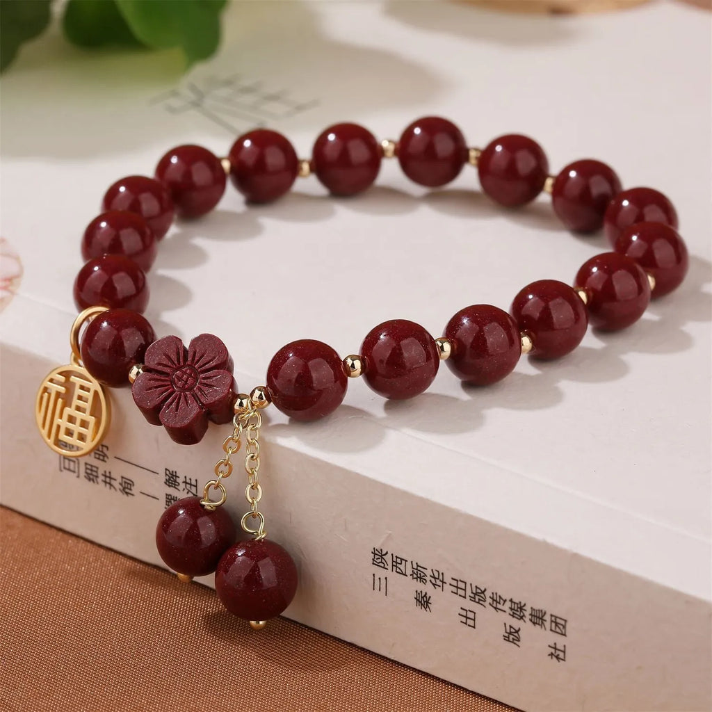 Women's cinnabar bracelet with Fu character charm and peach blossom tassels in purple gold sand colour