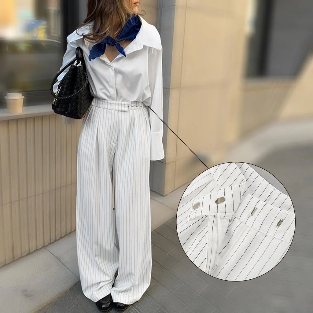 White striped wide-leg casual trousers with a zipper detail on a hanger.