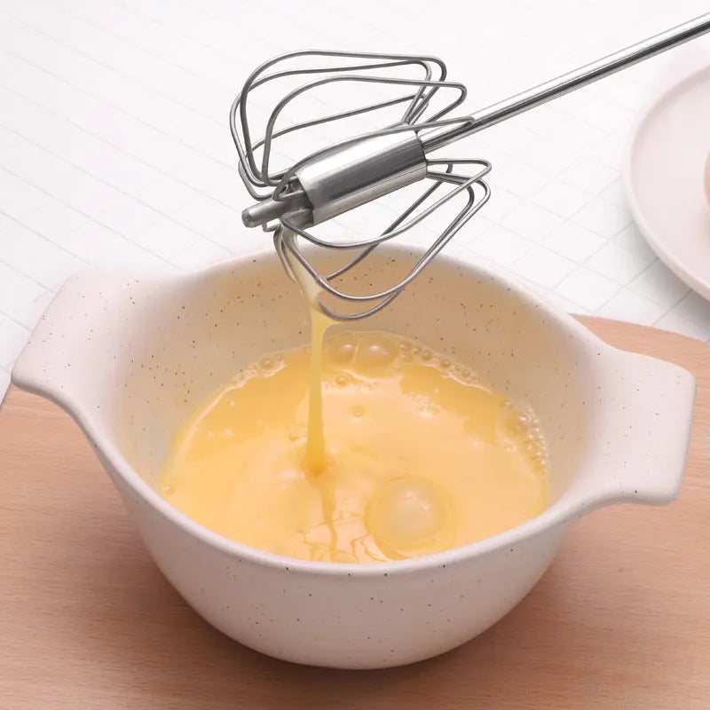 Self spinning whisk with stainless steel head and black handle on a white background