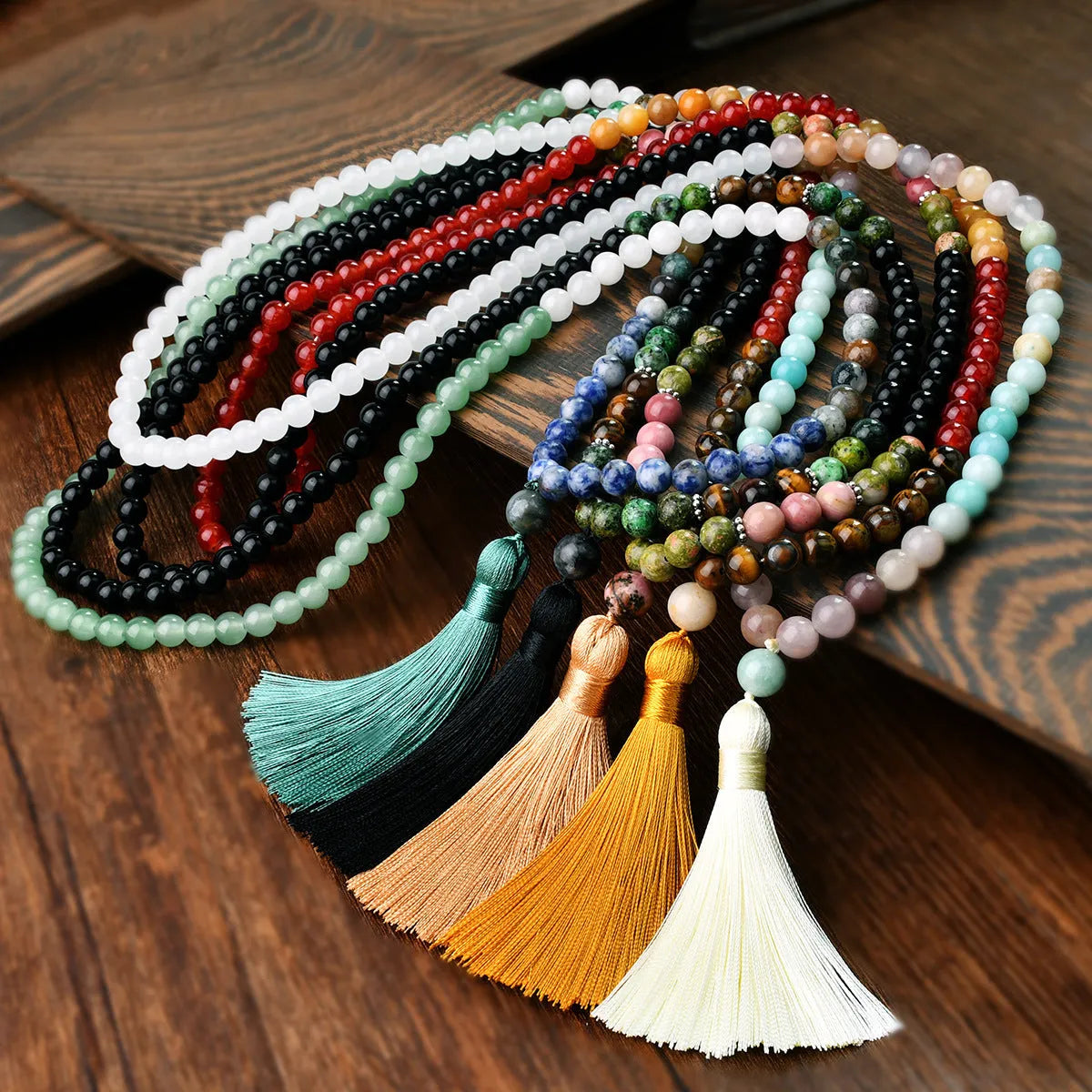 A long bohemian-style necklace with a geometric mixed gemstone pendant and a coloured tassel on a ball bead chain.