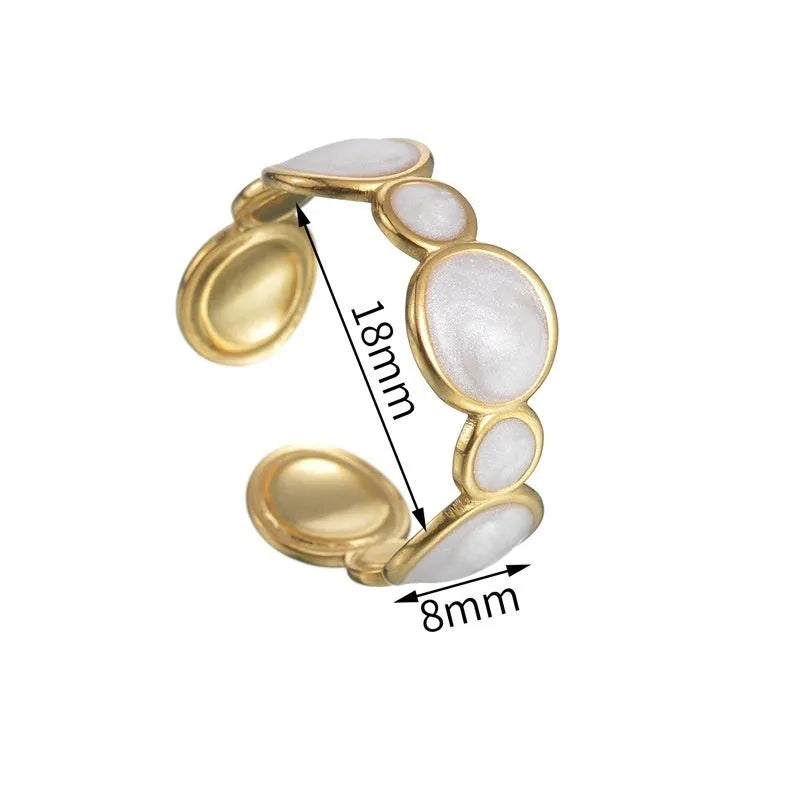 A stainless steel ring with a geometric design and adjustable opening on a plain background
