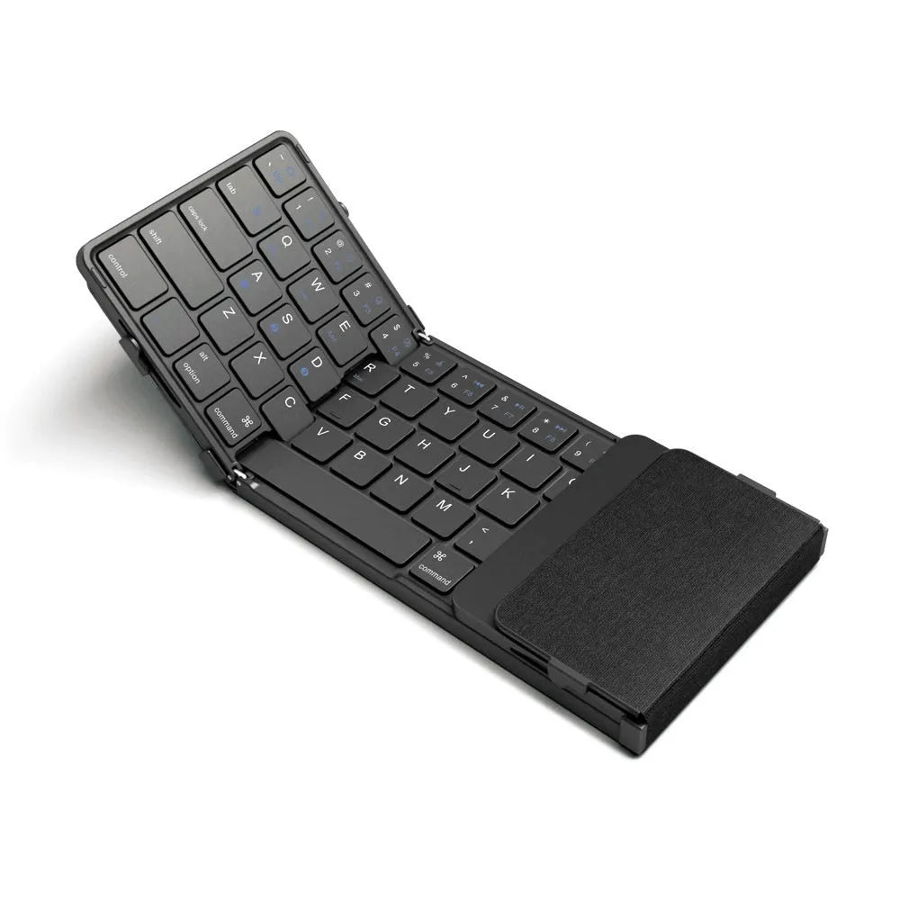 Black folding Bluetooth keyboard showing compact folded size beside mobile phone
