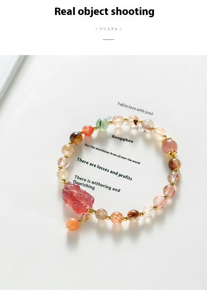 Close-up of a women's copper bracelet with a pink Strawberry Quartz crystal, a detailed Pixiu charm, and a white freshwater pearl.
