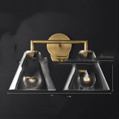 Gold bronze or black wall lamp with triangular transparent glass shade and wrought iron frame for bedside or hallway use
