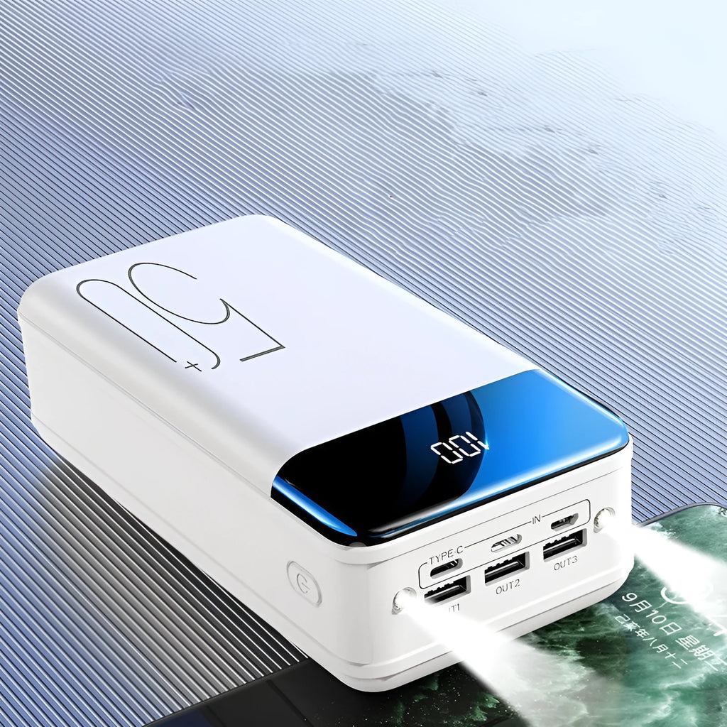 Black and white large 50000mAh portable power bank with multiple USB ports, showing scale next to a smartphone.