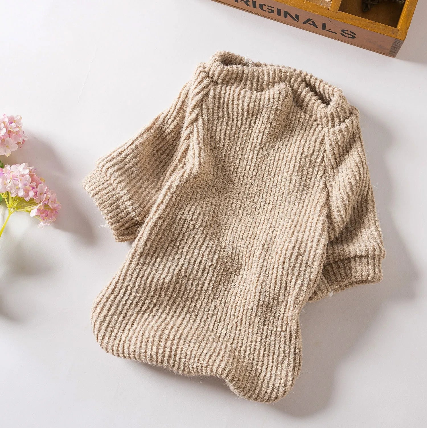 Brown knitted pullover sweater on a small dog, showing casual design and soft fabric.