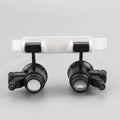 White foldable head-mounted magnifying glass with LED light for close-up repair work.
