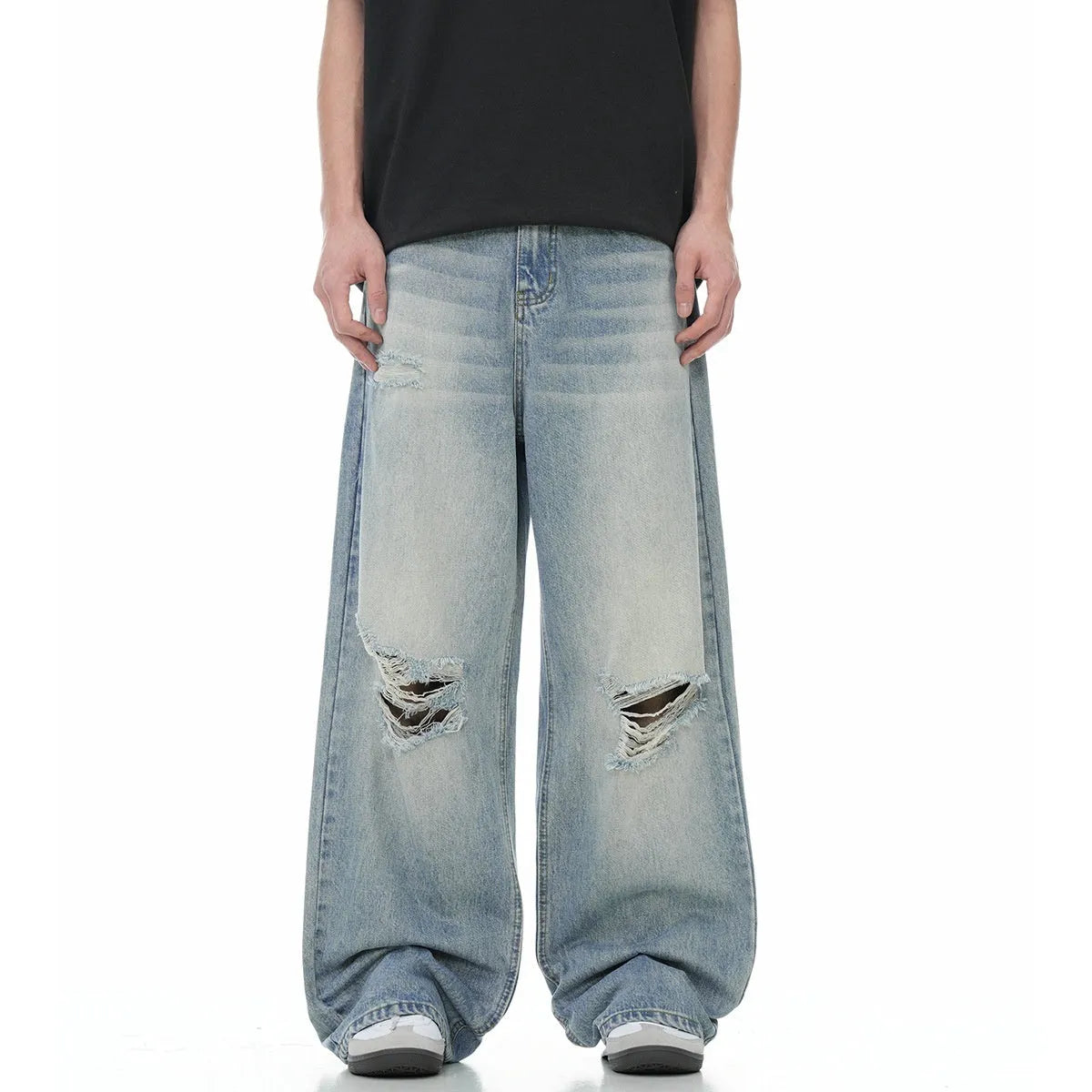 Man wearing blue ripped straight-leg jeans in a retro style with a zip fly.