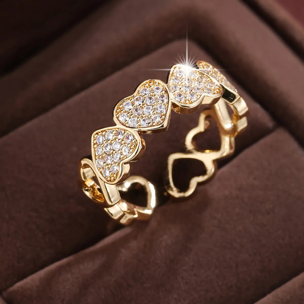 Geometric adjustable heart ring in gold plating, showing diamond-cut facets and open band design.