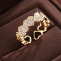 Geometric adjustable heart ring in gold plating, showing diamond-cut facets and open band design.