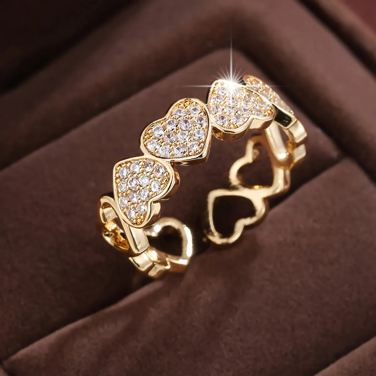 Geometric adjustable heart ring in gold plating, showing diamond-cut facets and open band design.
