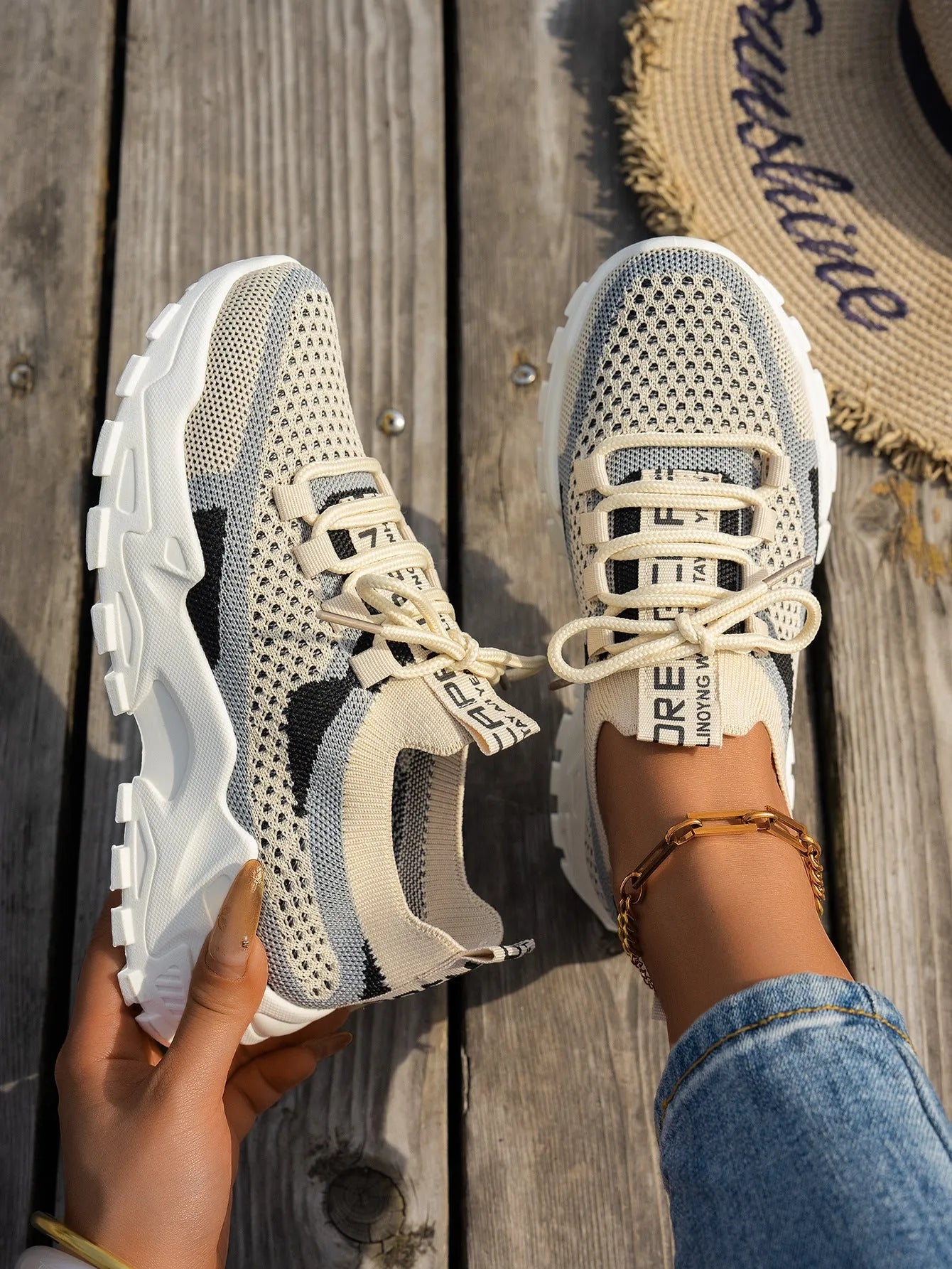 Women's Flyknit mesh lace-up sneakers in grey and white with a low rubber sole.