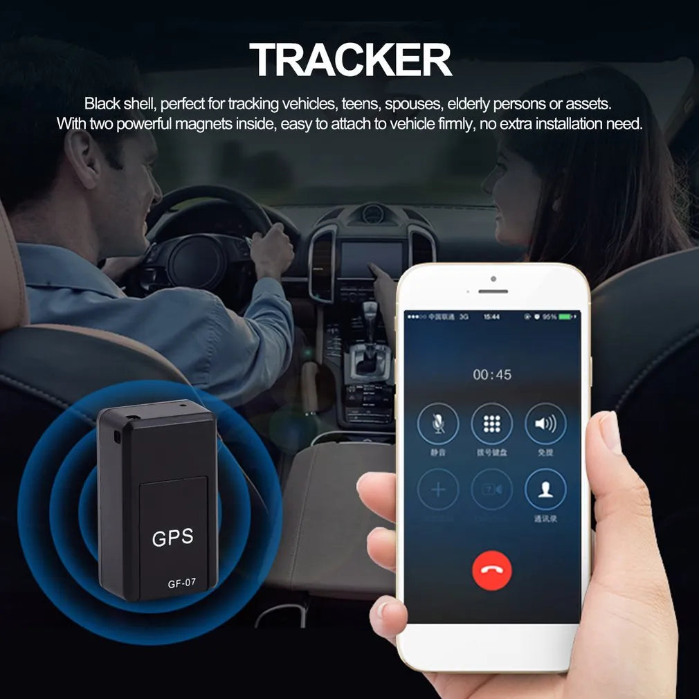 Small black magnetic GPS tracker device next to a USB charging cable on a table.