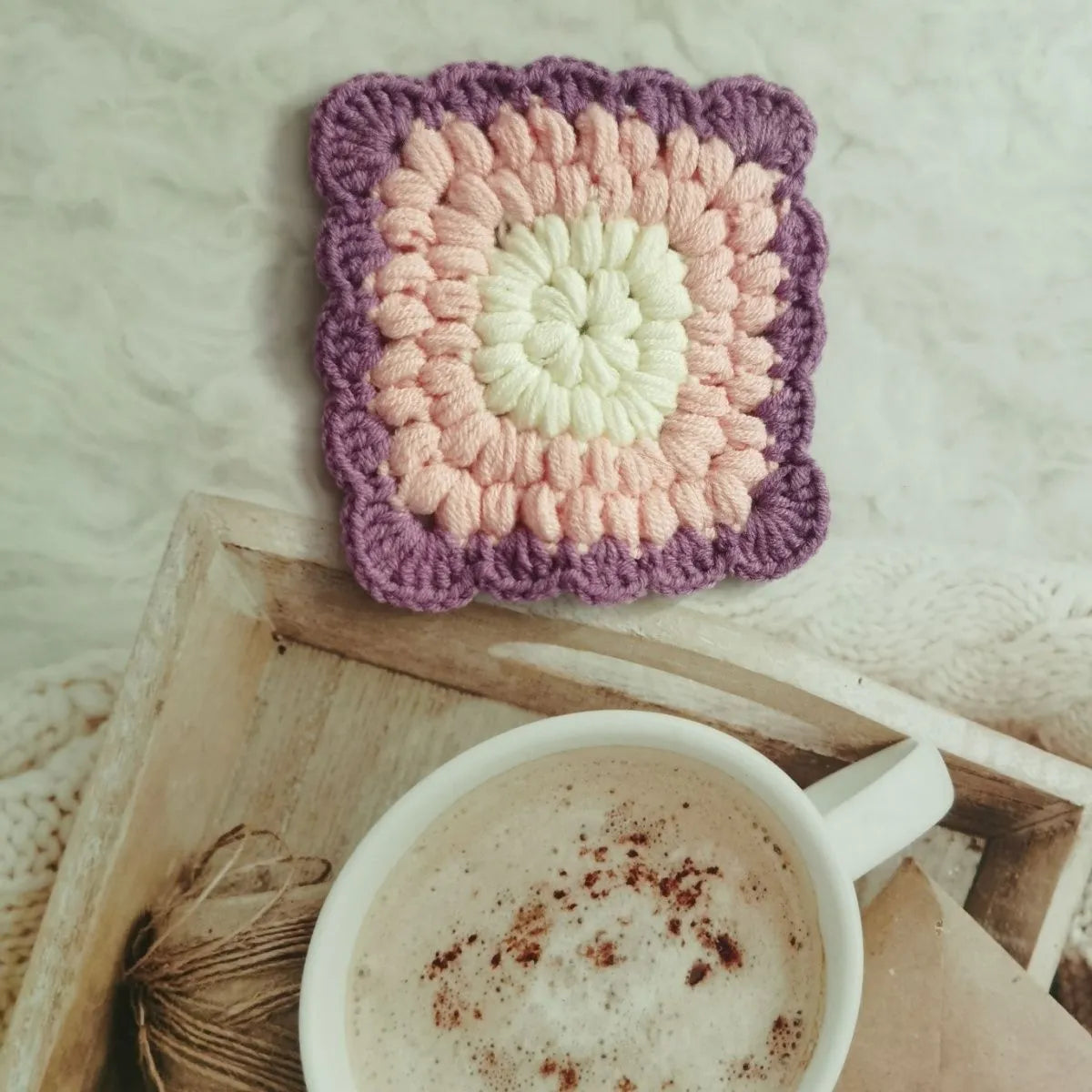 Handcrafted crocheted wool coaster with Grandmother Lattice stitch in a purple colour.