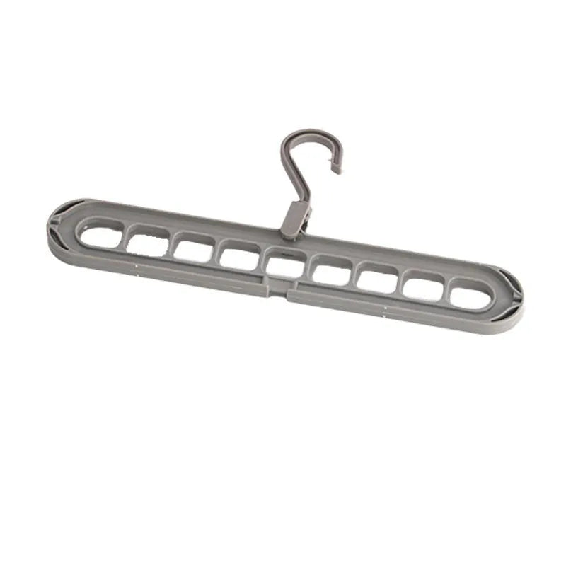 Green nine-hole plastic folding hanger for trousers and skirts showing multiple garment hanging points