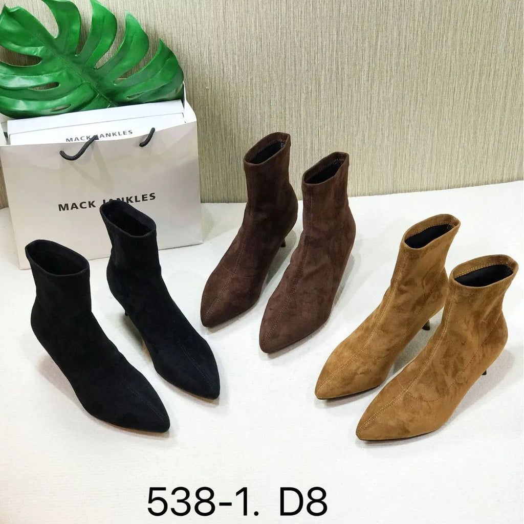 Black women's pointed toe ankle boots with a stiletto heel, shown on a foot.