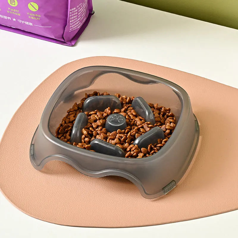 Blue plastic slow-feed dog bowl on a floor to prevent choking.