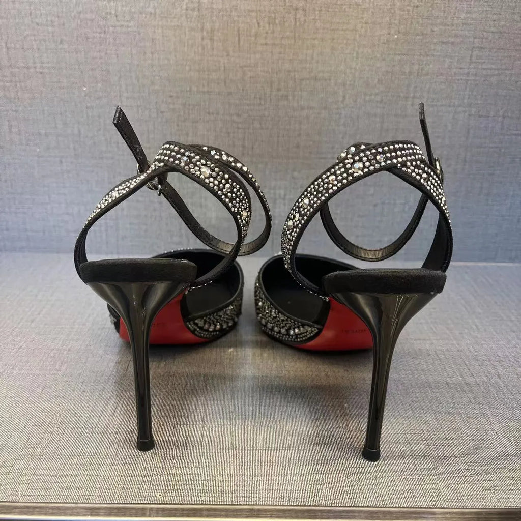 Women's silver and black hollow stiletto high heels with pointed toe and red sole on a plain background.