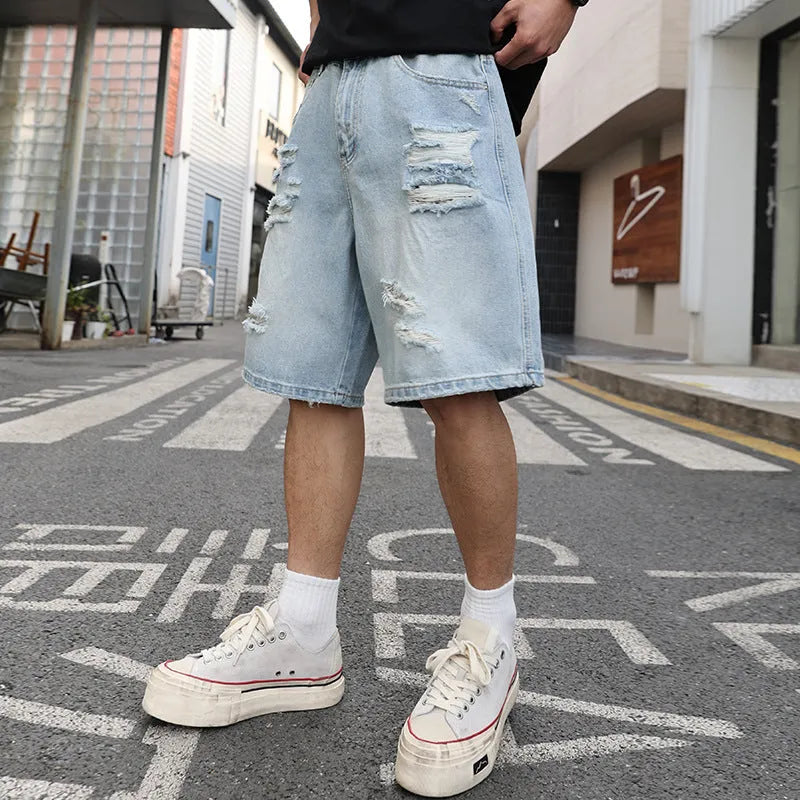 Men's light blue ripped denim shorts with distressed detailing and loose straight cut