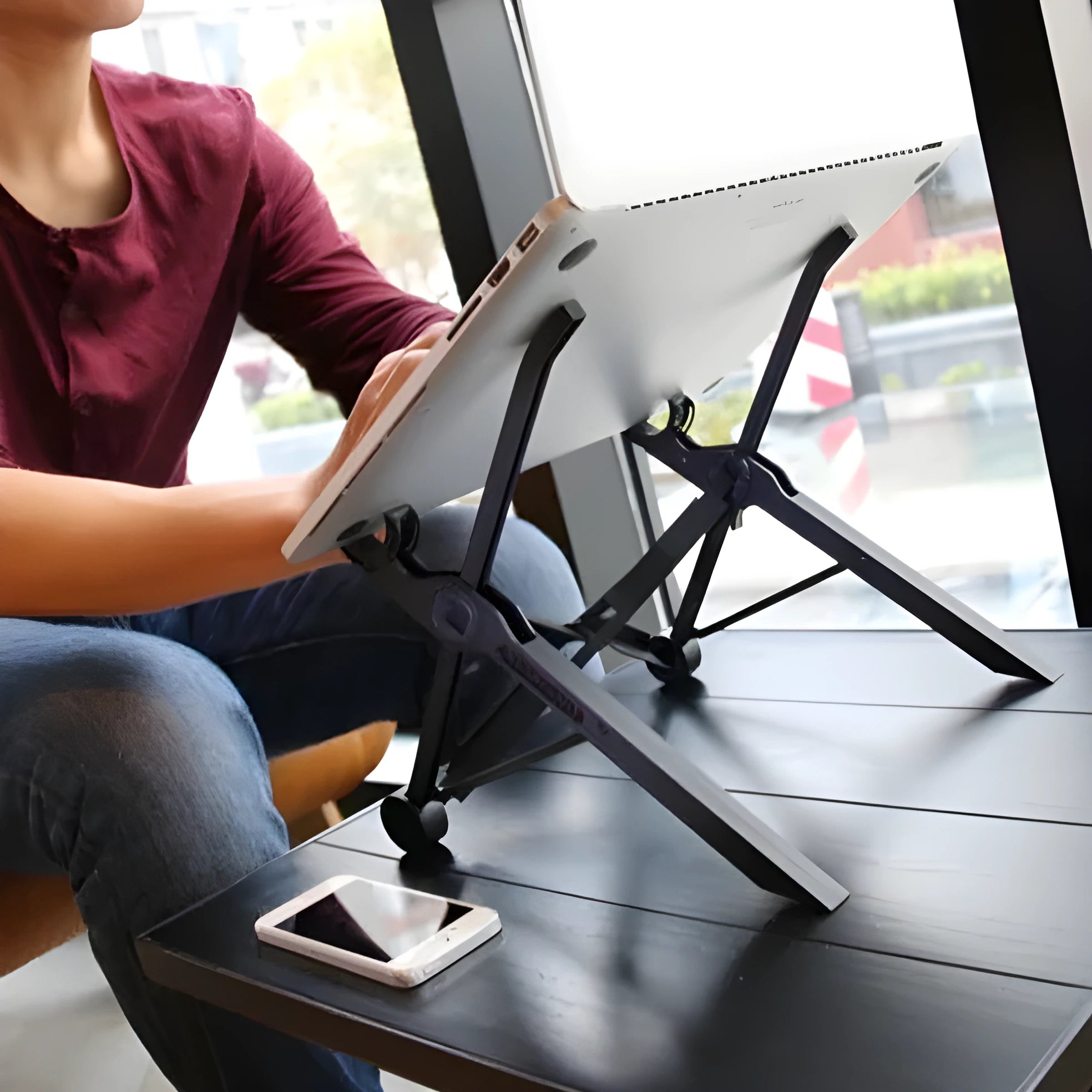 Sagacious black portable folding laptop bracket on a table with carrying case